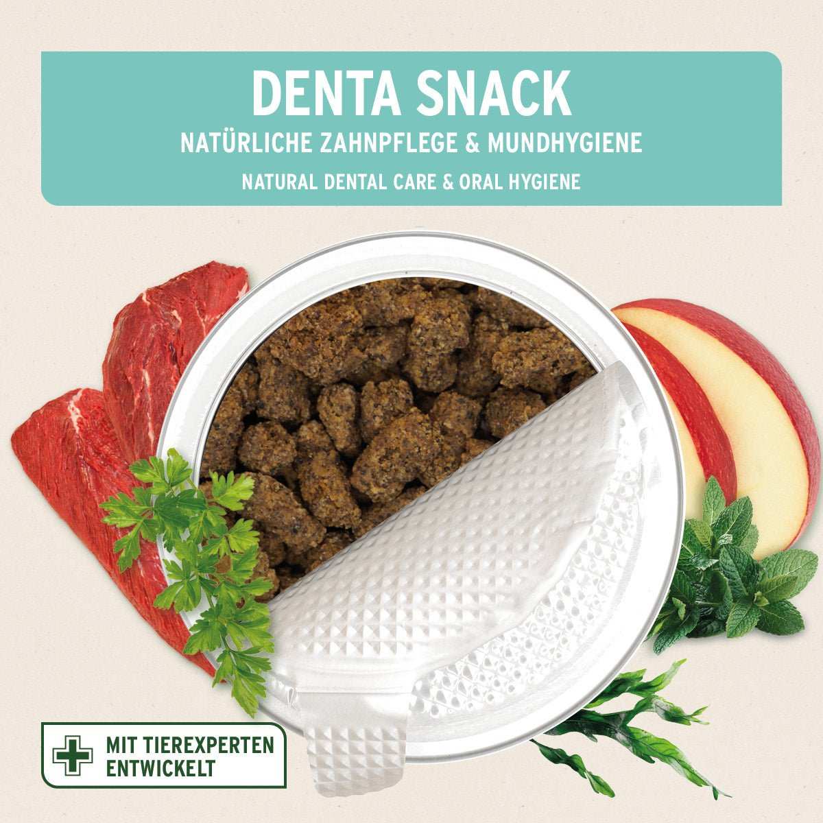 AniForte Denta Snack Dose mit Denta Snack Zahnpflege-Snacks, umgeben von rohem Fleisch, Apfelscheiben, Kräutern und Minze.