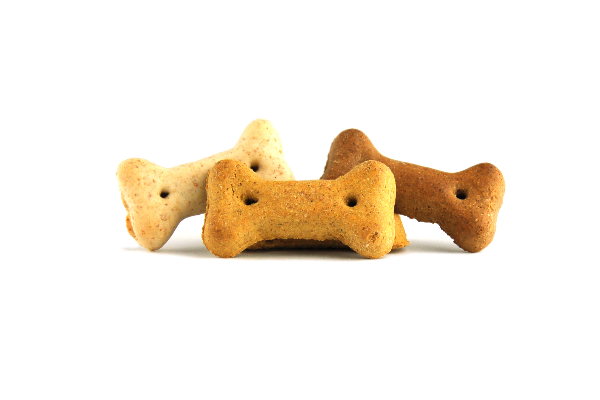Drei Hundekekse in Knochenform, verschiedene Brauntöne, ohne Verpackung.