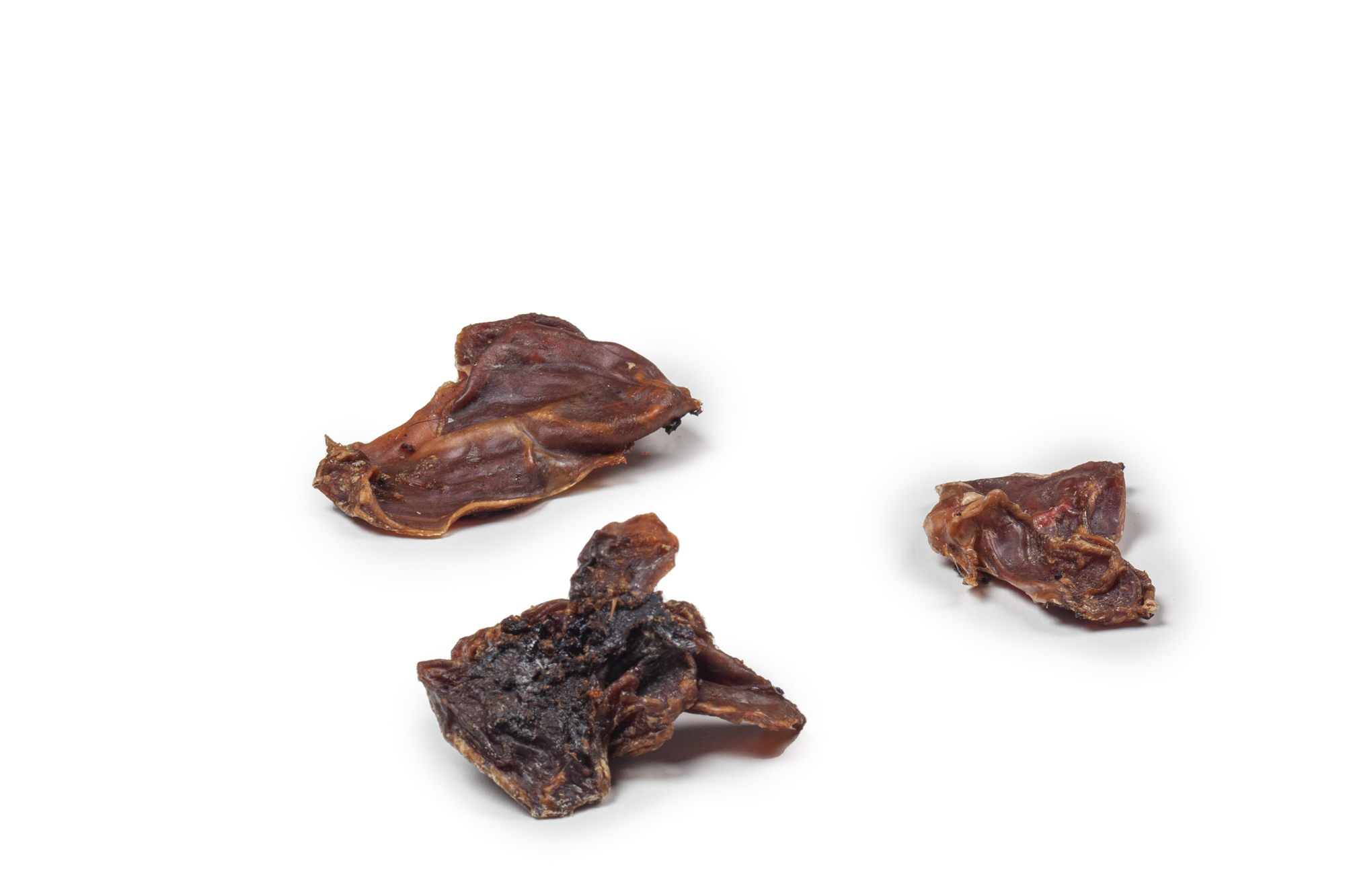 DIBO Hähnchen-Mägen, 100g-Beutel Drei getrocknete Hähnchenmägen auf weißem Hintergrund
