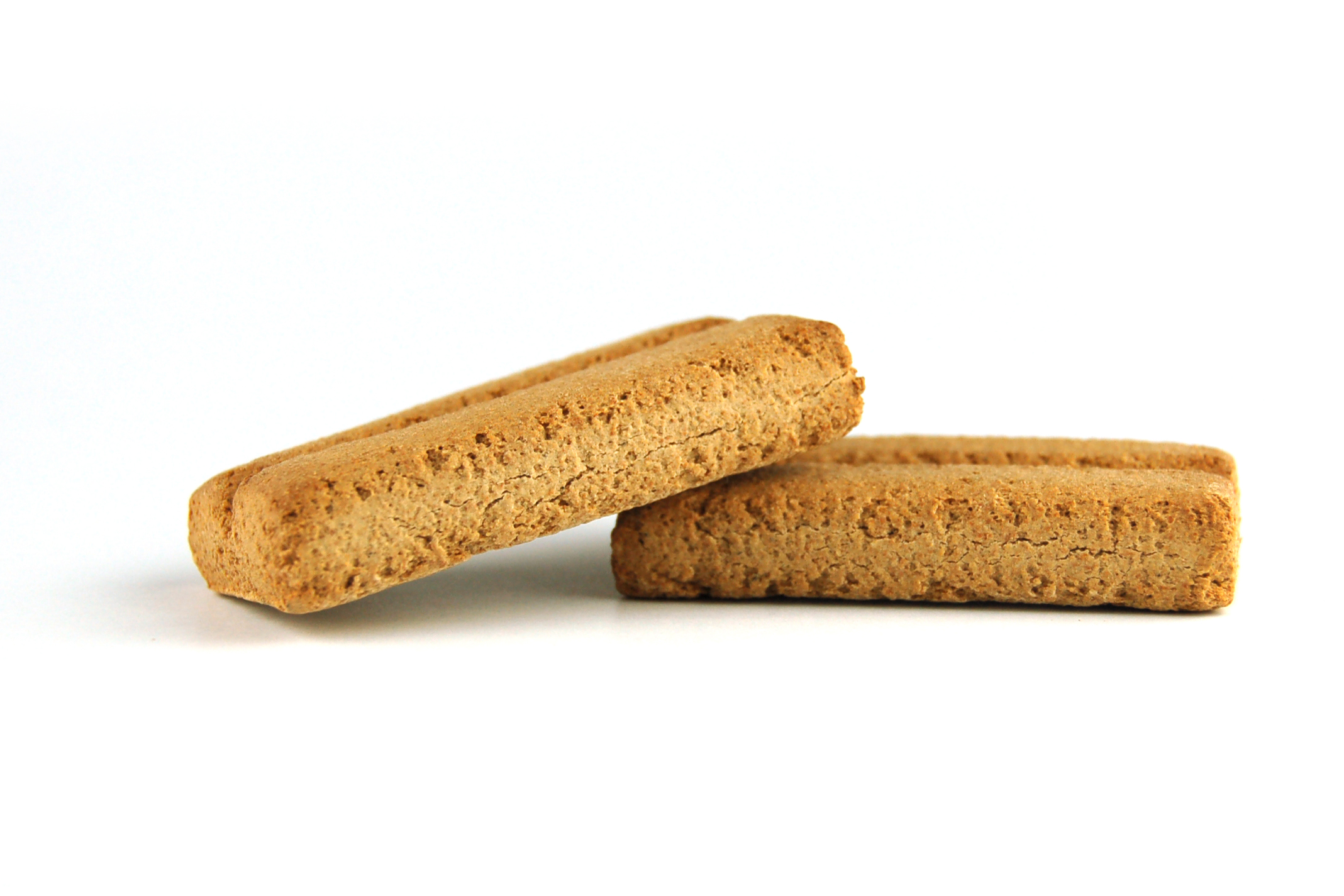 Zwei rechteckige, goldbraune Hundekekse, texturierte Oberfläche, weißer Hintergrund.