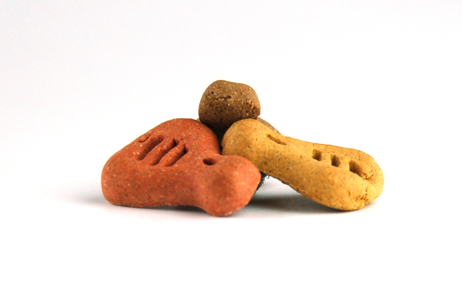 Hunde-Leckerlis, knochenförmig, rotbraun und beige, gestanztes Pfotenmuster.